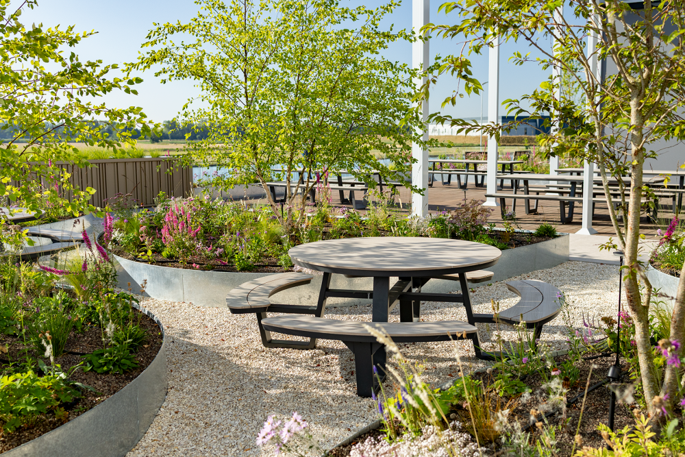 Bedrijfstuin met picknicktafels en groene beplanting